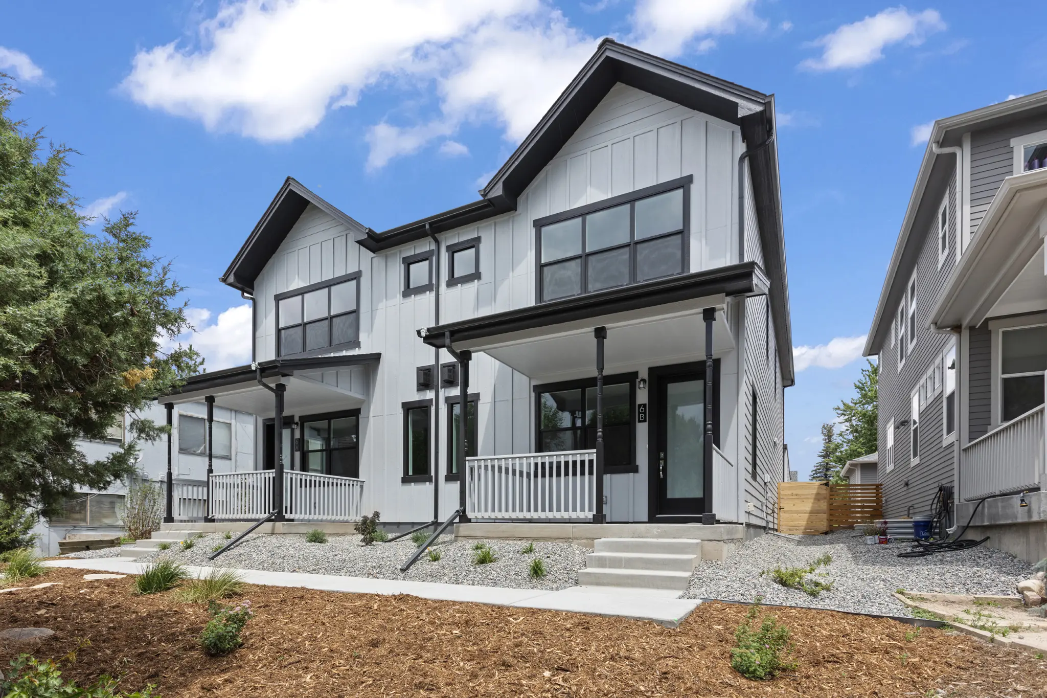 Modern white duplex with black trim porches