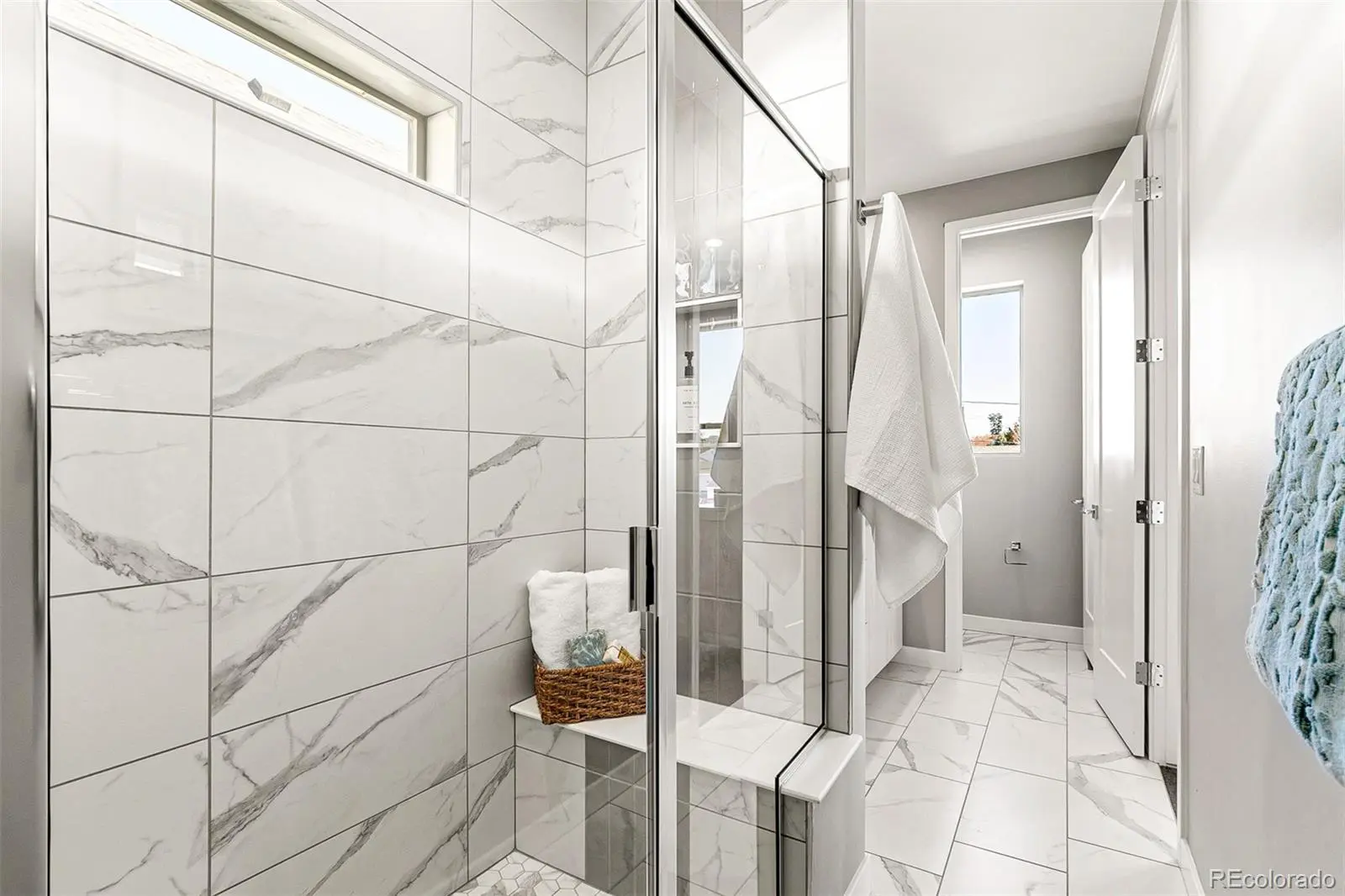 Modern marble-tiled bathroom with glass shower